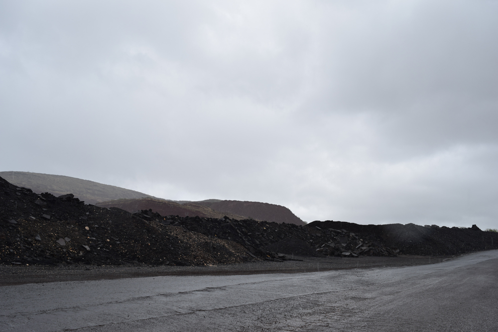 Stockpiles of reclaimed pavement materials at a recycling site.